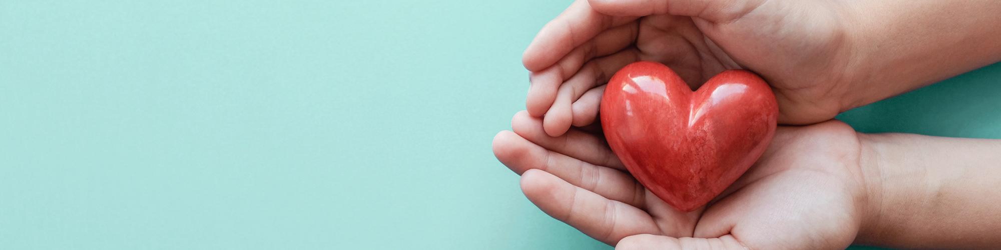 hands holding a small ceramic heart